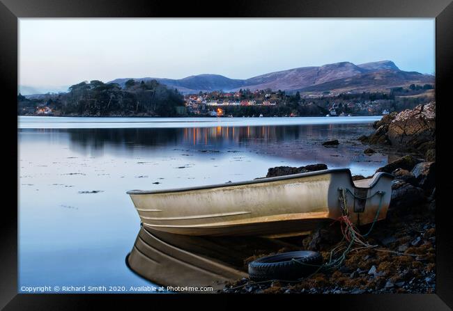 A dinghy moored at the loch's edge with reflected view of Portree  Framed Print by Richard Smith