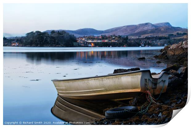 A dinghy moored at the loch's edge with reflected view of Portree  Print by Richard Smith