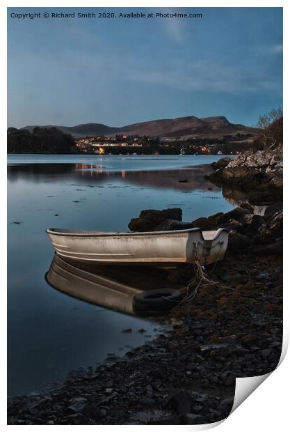 A dinghy moored on the shore of loch Portree reflected in the water  Print by Richard Smith