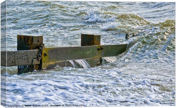 Waves break over a wooden groyne at Southend on Sea, Essex, UK Canvas Print by Peter Bolton