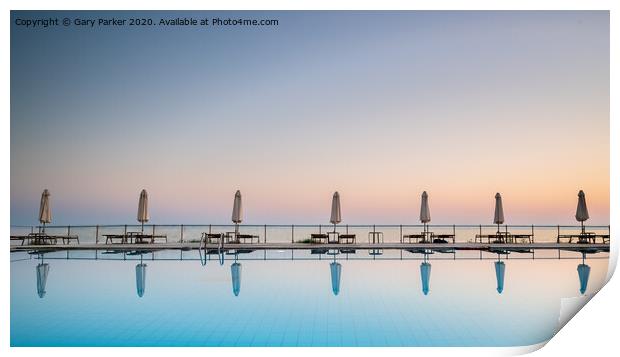 row of sunbeds and sun shades, reflecting in a still swimming pool, as the sun sets, in the Mediterranean	 Print by Gary Parker