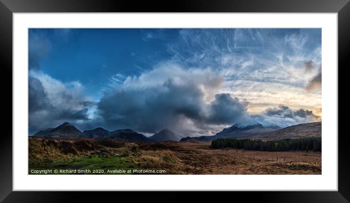 The sun setting to the right of a panorama of the red and black Cuillin Hills. Framed Mounted Print by Richard Smith