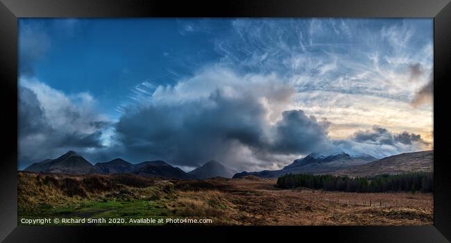 The sun setting to the right of a panorama of the red and black Cuillin Hills. Framed Print by Richard Smith