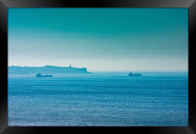 cargo ships with lighthouse in the background Framed Print by David Galindo