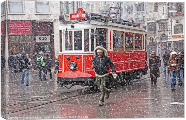 A nostalgic tram was passing by The Istiklal Street when snowfalls at Istanbul Canvas Print by Engin Sezer