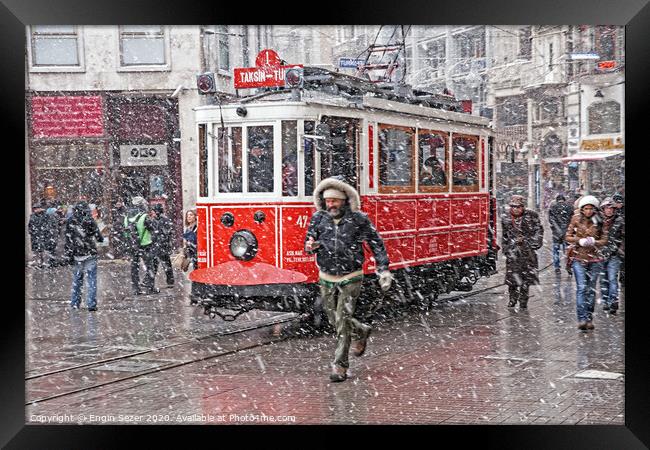 A nostalgic tram was passing by The Istiklal Street when snowfalls at Istanbul Framed Print by Engin Sezer