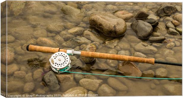 Spey fly rod and reel resting on wet rocks beside a river. Canvas Print by SnapT Photography