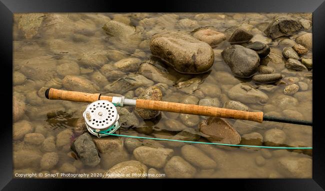 Spey fly rod and reel resting on wet rocks beside a river. Framed Print by SnapT Photography