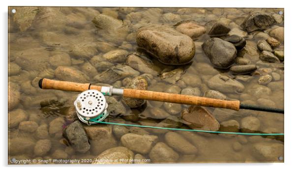 Spey fly rod and reel resting on wet rocks beside a river. Acrylic by SnapT Photography