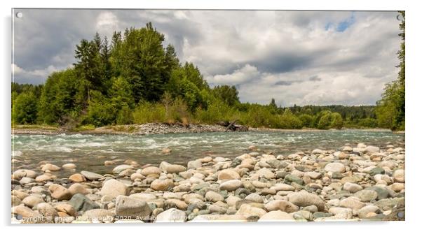 A boulder strewn, fast flowing river, beside a forest, on a cloudy day. Acrylic by SnapT Photography