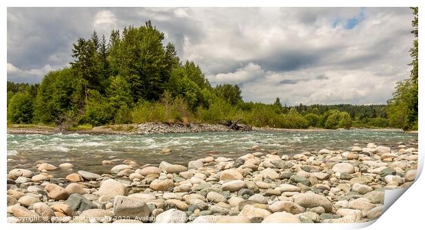 A boulder strewn, fast flowing river, beside a forest, on a cloudy day. Print by SnapT Photography