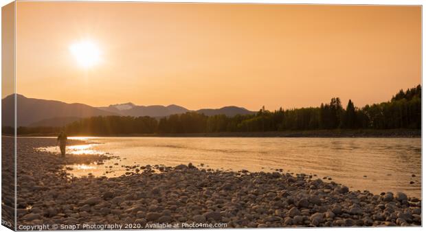 A fisherman walking along a gravel bar beside the Skeena River at sunset Canvas Print by SnapT Photography