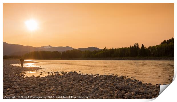 A fisherman walking along a gravel bar beside the Skeena River at sunset Print by SnapT Photography