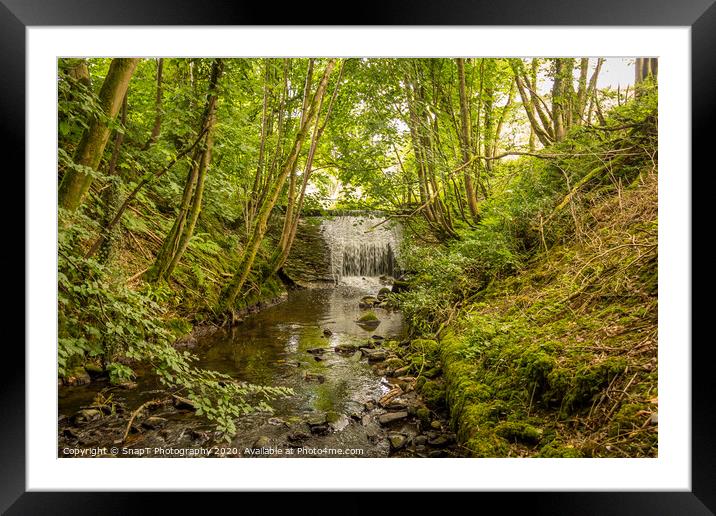 Water flowing over an old weir and through a woodland, over stones Framed Mounted Print by SnapT Photography