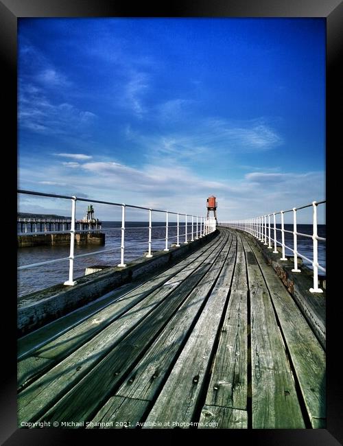 View along the East Pier at Whitby, North Yorkshir Framed Print by Michael Shannon