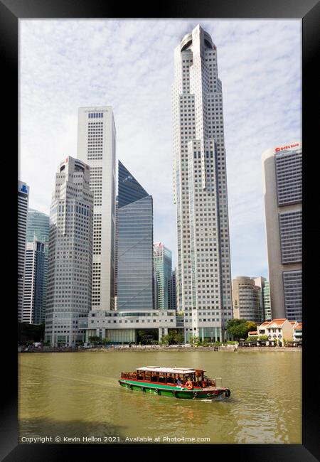 Bumboat on the Singapore river with the tall buildings of the fi Framed Print by Kevin Hellon