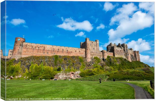 Kite flyer at Bamburgh Castle Canvas Print by Angus McComiskey