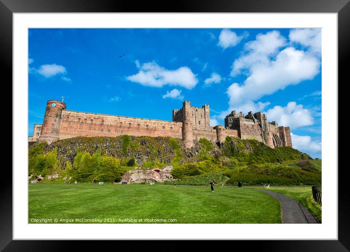Kite flyer at Bamburgh Castle Framed Mounted Print by Angus McComiskey