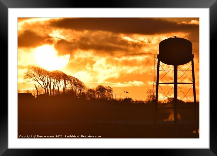 A building with a sunset in the background Framed Mounted Print by Duane evans
