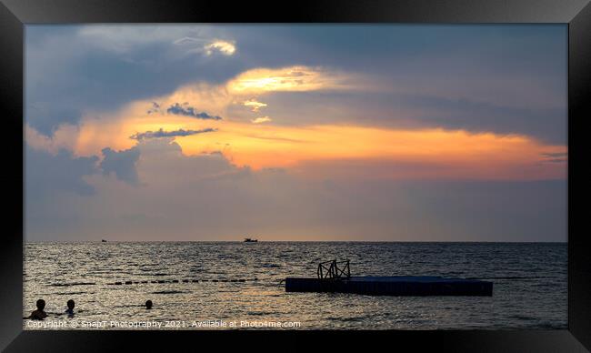 Silhouette of bathers and floating pier at sunset  Framed Print by SnapT Photography