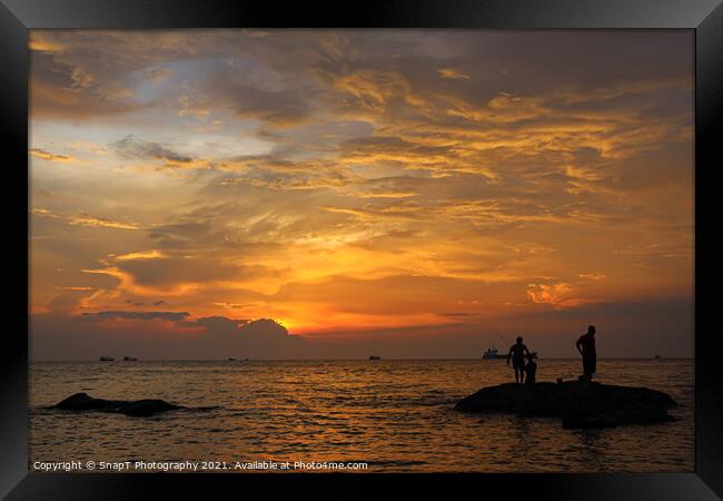 A silhouette of fishermen standing on rocks at sun Framed Print by SnapT Photography