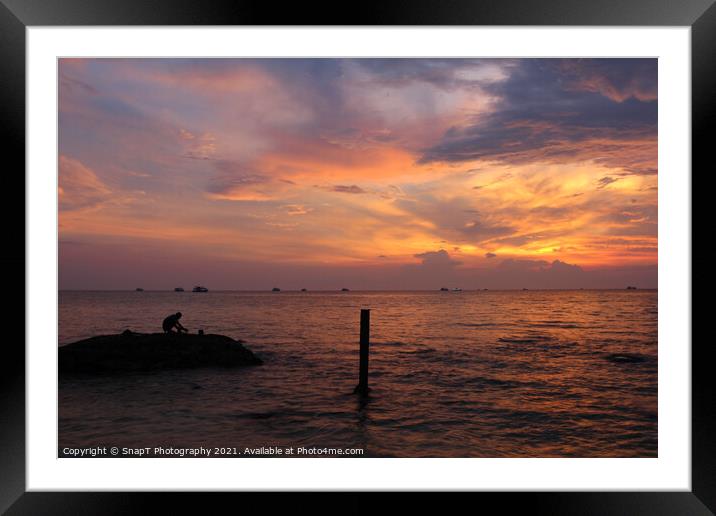 A beautiful sunset and silhouette of a person on a rock, at Ba Keo Beach Framed Mounted Print by SnapT Photography