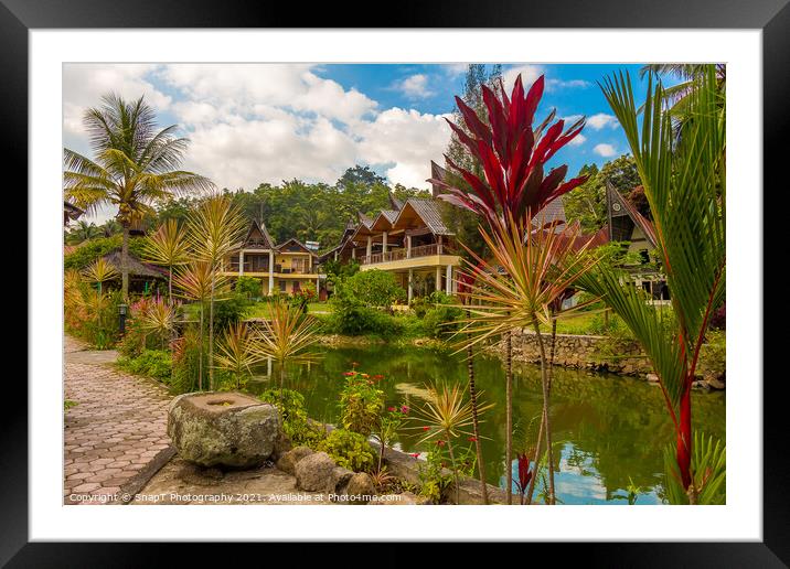 A lake and a Bataknese architecture on the shore of Lake Toba Framed Mounted Print by SnapT Photography