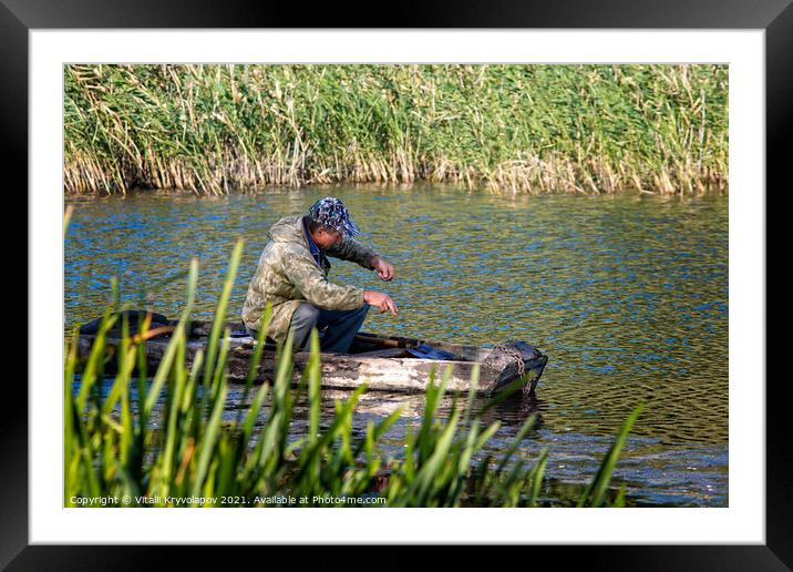 A fisherman in a wooden boat is fishing.  Framed Mounted Print by Vitalii Kryvolapov