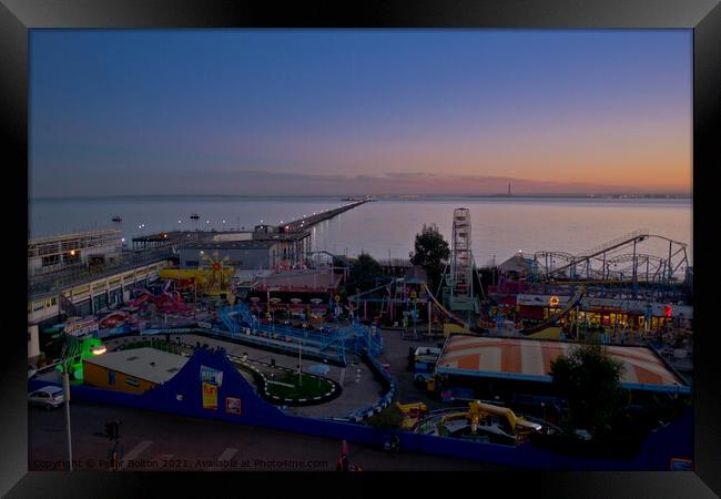 Evening view of the seafront at Southend on Sea showing 'Adventure Island' and the pier. Framed Print by Peter Bolton
