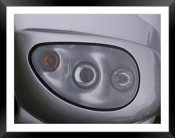Silver sports car headlight Framed Mounted Print by Allan Briggs