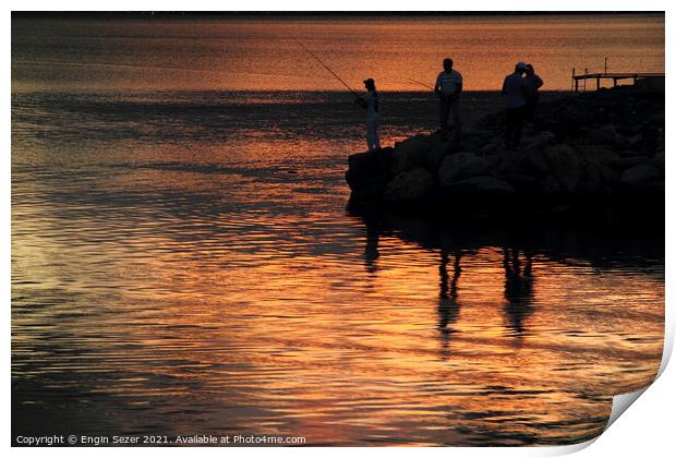 Silhouette of fishing people standing next to a bo Print by Engin Sezer