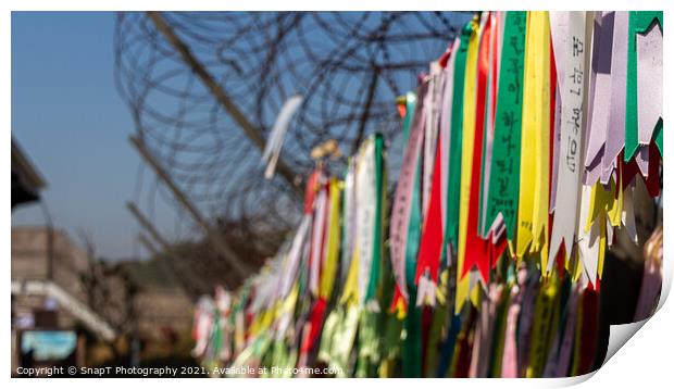 Prayer ribbons attached to a barb wire fence at the Korean Demilitarized Zone Print by SnapT Photography