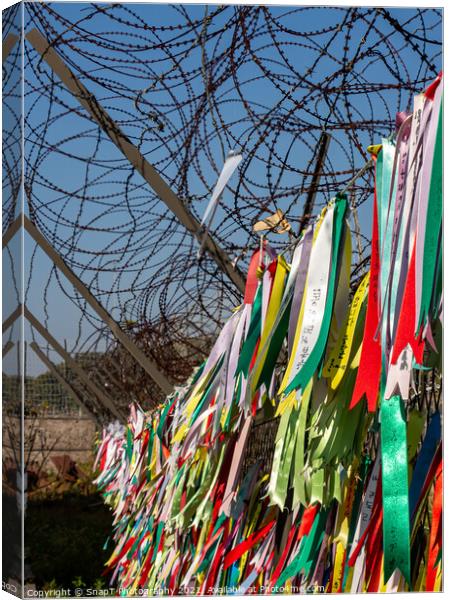 Prayer ribbons attached to a barb wire fence at the Korean Demilitarized Zone Canvas Print by SnapT Photography