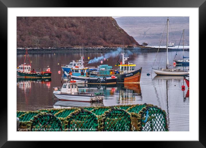 Fishermen at work in Portree harbour photographed from behind a stack of creels. Framed Mounted Print by Richard Smith