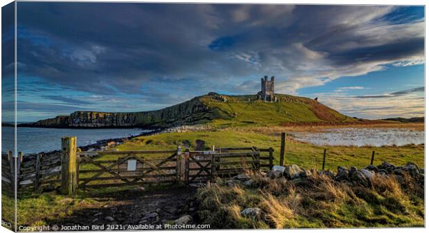 Winter Sun on Dunstanburgh Castle Canvas Print by Jonathan Bird