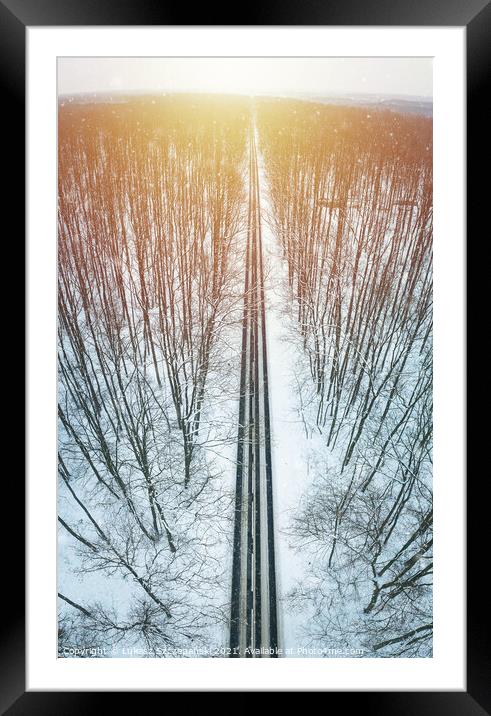 Road through winter forest towards setting sun Framed Mounted Print by Łukasz Szczepański