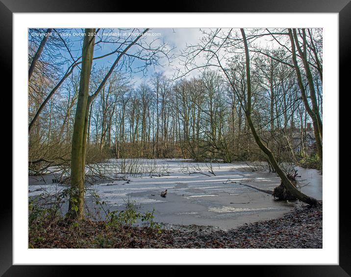 Frozen pond with snow surrounded by trees  Framed Mounted Print by Vicky Outen