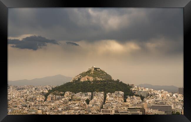 Lycabettus hill rises above Athens on stormy day Framed Print by Steve Heap