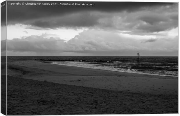 Moody, cloudy skies over Caister beach  Canvas Print by Christopher Keeley