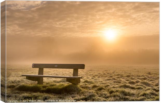 A bench at sunrise on a foggy winter morning Canvas Print by Gary Holpin