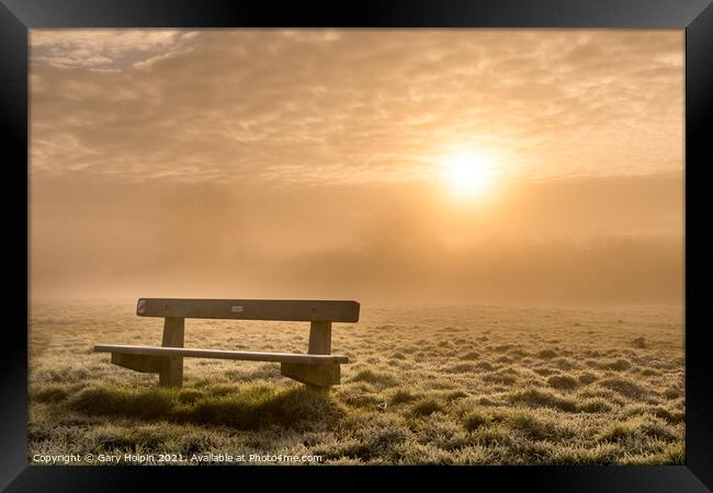A bench at sunrise on a foggy winter morning Framed Print by Gary Holpin