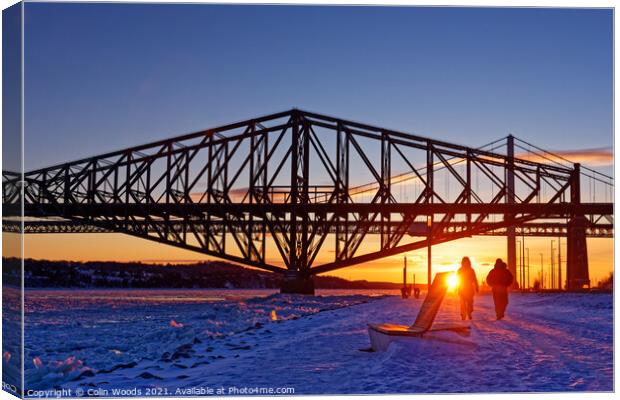 People going for an evening walk at sunset by the frozen St Lawrence River, Quebec, Canada Canvas Print by Colin Woods