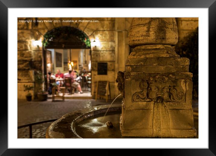 Roman fountain, with a small Trattoria in the background, at night Framed Mounted Print by Gary Parker