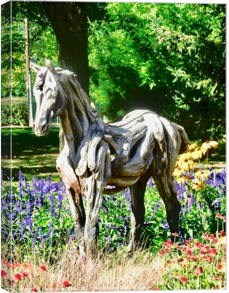 A wooden horse standing in flowers Canvas Print by Stephanie Moore