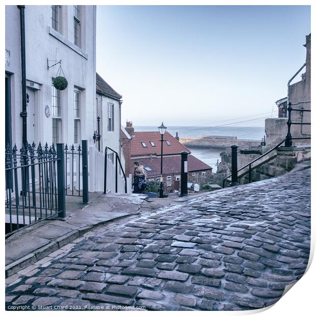 Whitby town cobbled streets and sea view Print by Stuart Chard