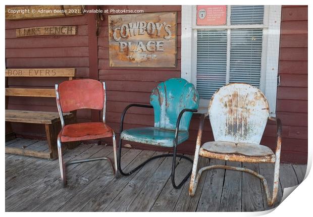 Coloured chairs on a cowboy veranda Print by Adrian Beese