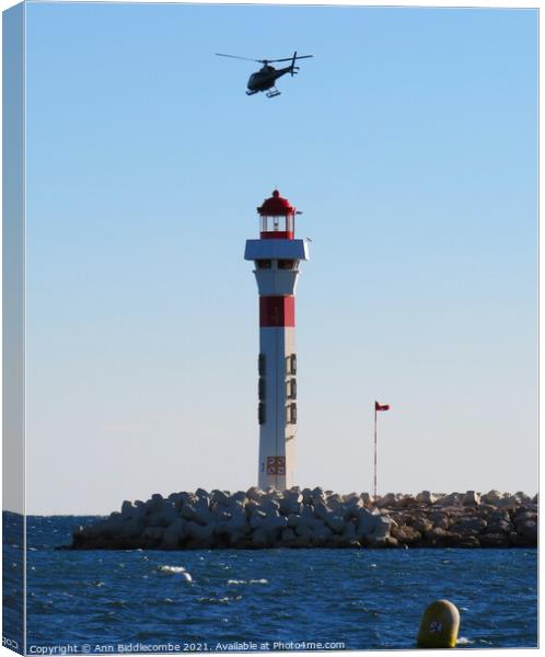 Helicopter above the Lighthouse Canvas Print by Ann Biddlecombe