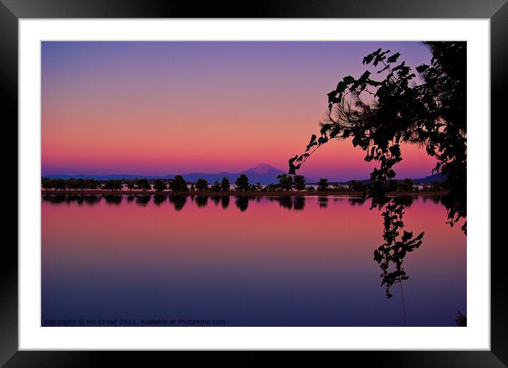Vivid Sunset with Silhouetted trees and reflection Framed Mounted Print by Nic Croad