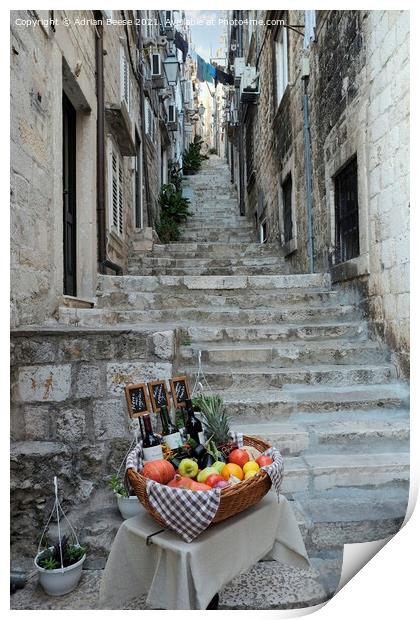 Basket of wine and fruit in Dubrovnik Print by Adrian Beese