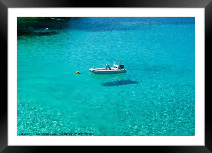 Boat floating on crystal clear water Framed Mounted Print by Nic Croad